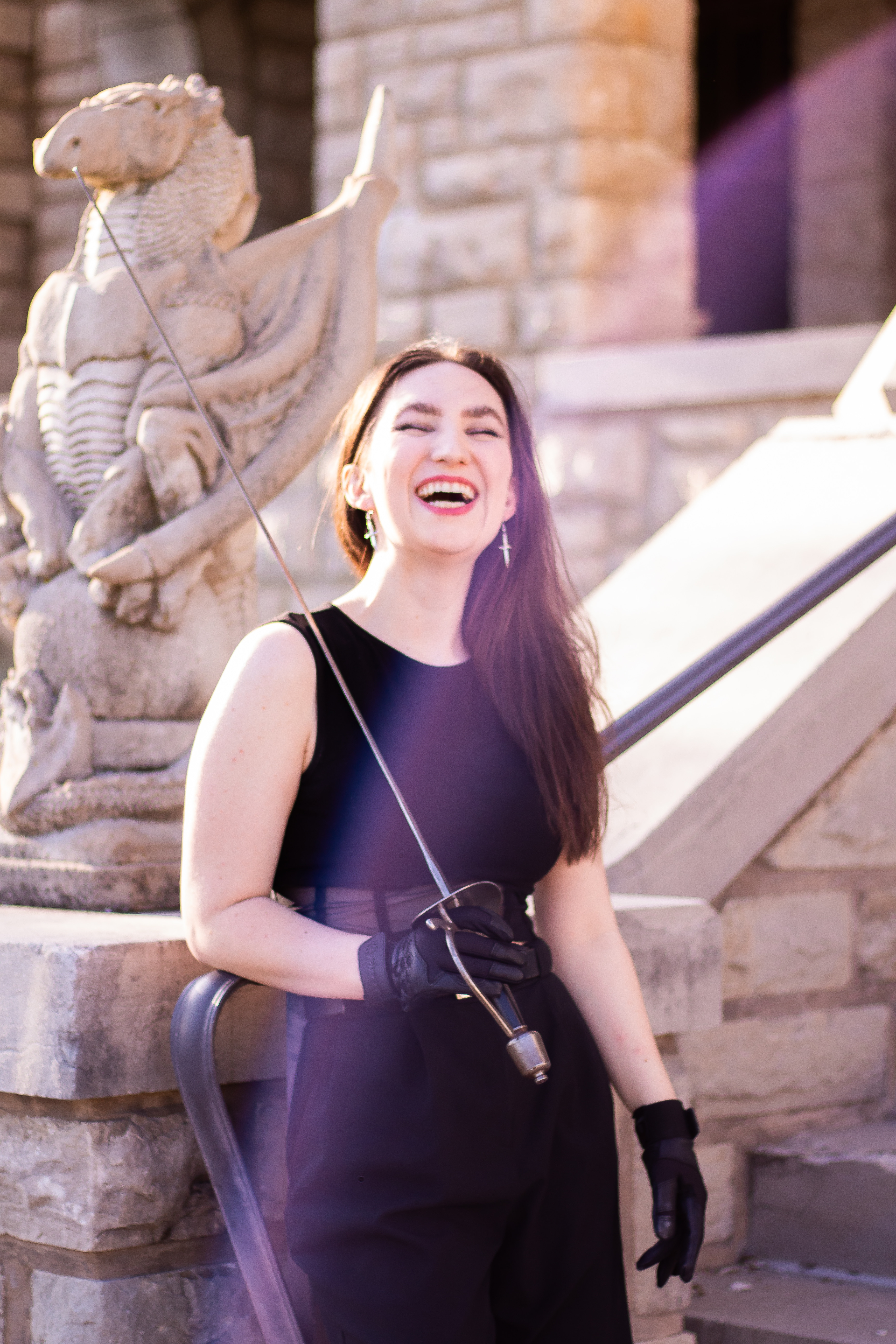 Annie Oberholtzer, laughing and smiling with a fencing sword in hand