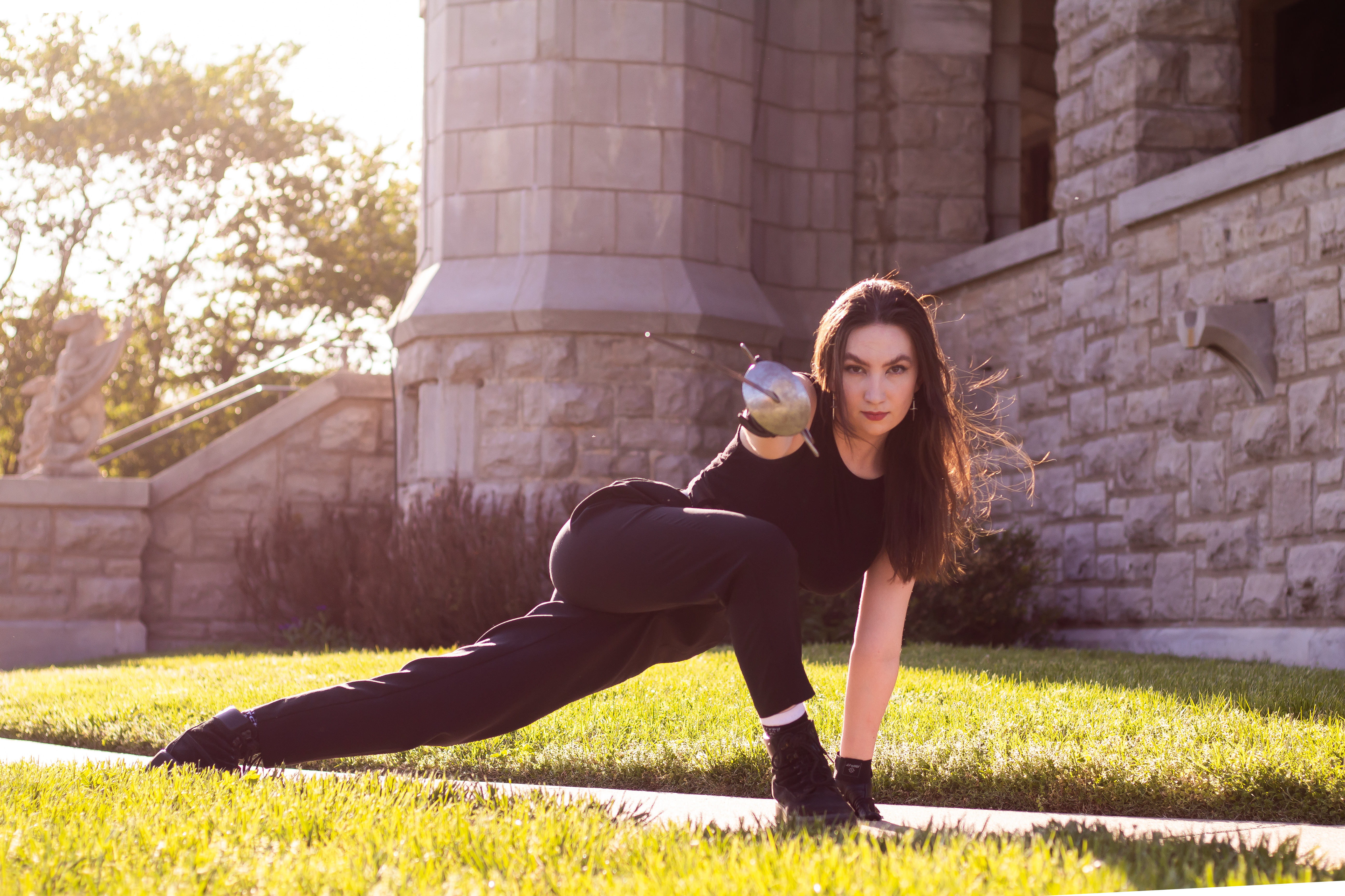 Annie with fencing sword in a lunge.